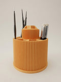 Rotating brush carousel in mandarin orange loaded with paint and makeup brushes, angled hero view