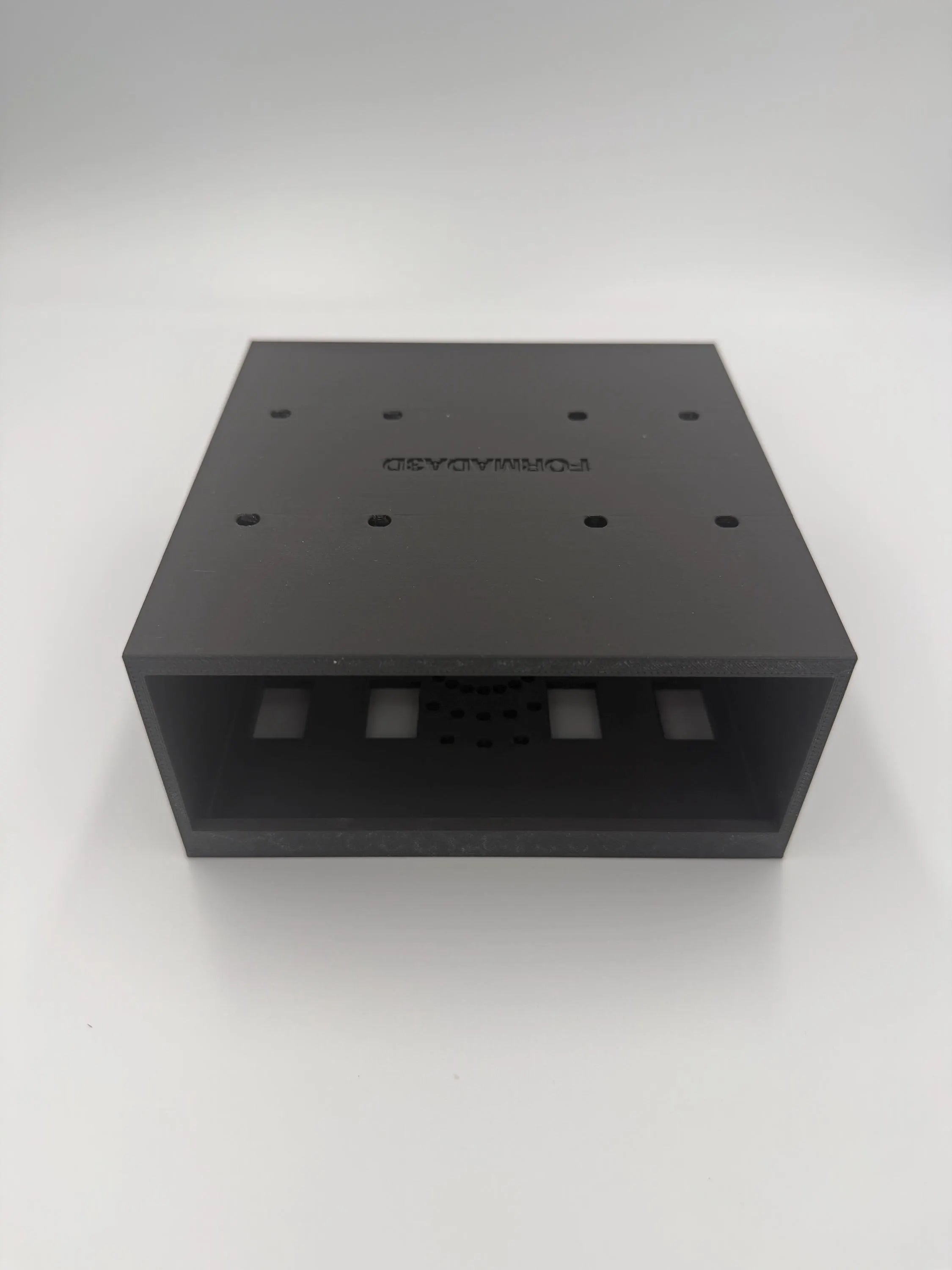 Detail view of the Mac Mini M4 under-desk mount showing ventilation and mounting holes