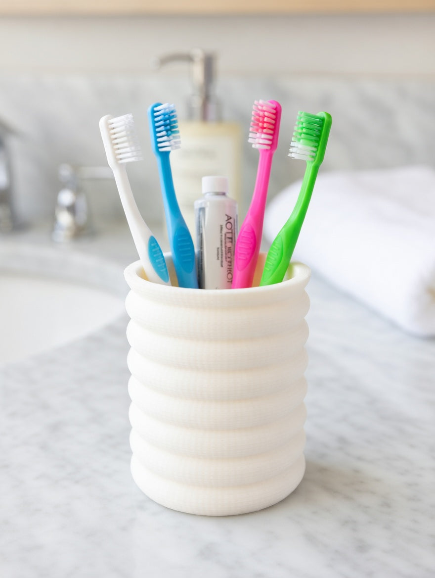 Cream ivory Knit Stack holder used for brushes on a marble bathroom countertop