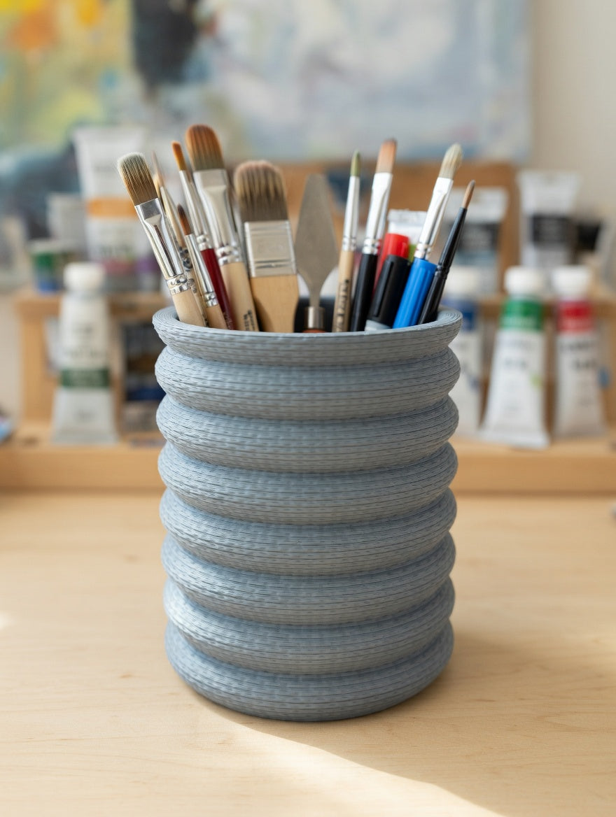 Light grey Knit Stack pencil holder in an art studio surrounded by supplies