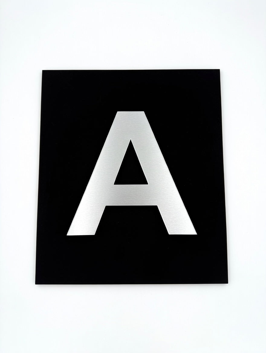 Silver letter A on a black base plate, front view